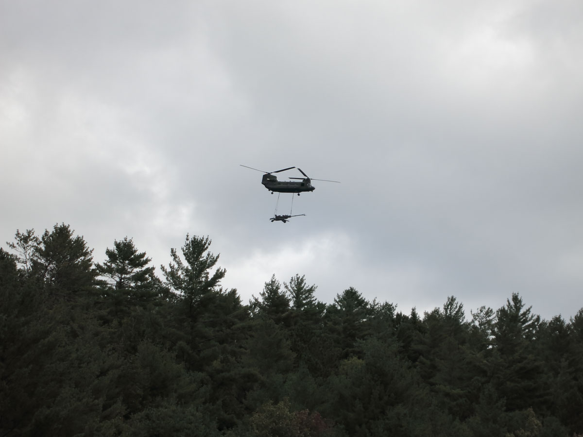 Chinook helicopter carrying artillery piece over McManus Lake on the Petawawa River in Algonquin Park